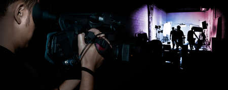 cameraman record movie with digital camera make clip in media production on dark background (banner size)の写真素材