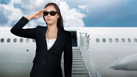 Asian smart woman business uniform with private jet on airplane stair at airportの写真素材