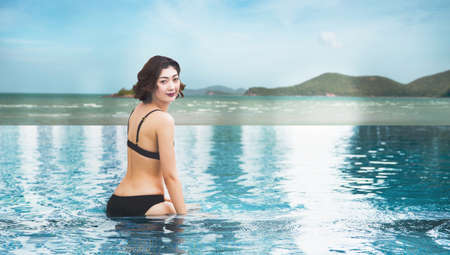 sexy lady in swimming suite posting water pool. Relax in holiday conceptの写真素材