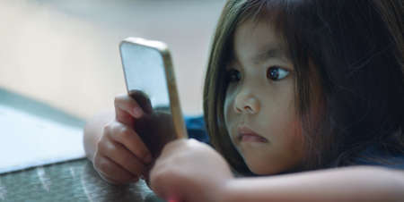 worries eye health with addict kids watching close up mobile phone screen to play game or using internetの写真素材