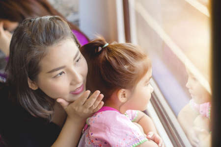 mother explain to daughter in adventure trip with train and see outsideの写真素材