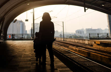 silhouette passenger walking on walkway at eletrict train station in city life concept