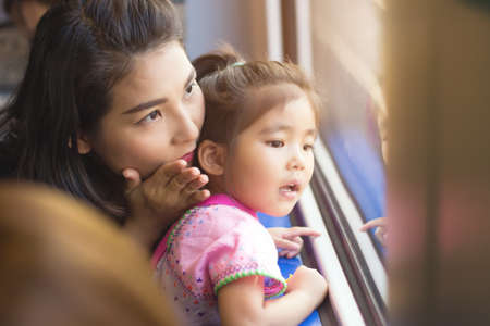 mother explain to daughter in adventure trip with train and see outsideの写真素材