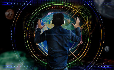backyard asian man controld digital graphic sign with virtual glasses on screen with earth and space galaxy on backgroundの写真素材