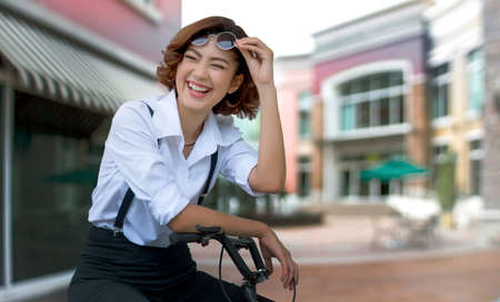 big smile face from attractive asian lady on bycicle hand on streetの写真素材