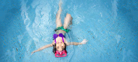 happy asian kid big smile to playing swim in water pool at summer with banner size