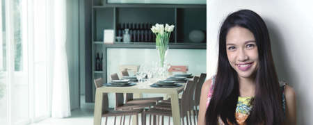 asian wife happy in house work to preparing dinner table. woman model smiling onnext living room.の写真素材