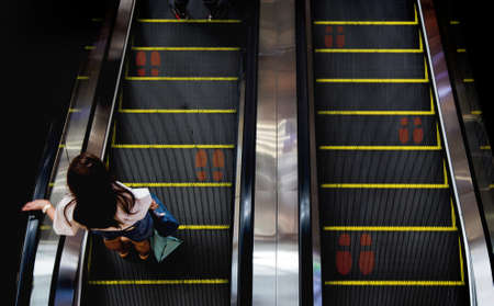 Foot point print sign on escalator in modern trade to maintain distance during the Covid-19 coronavirus pandemicの写真素材