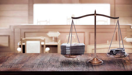 balancing of money and shackle on scales in courtroom with to magistrate in cour in the law of adjustment conceptの写真素材