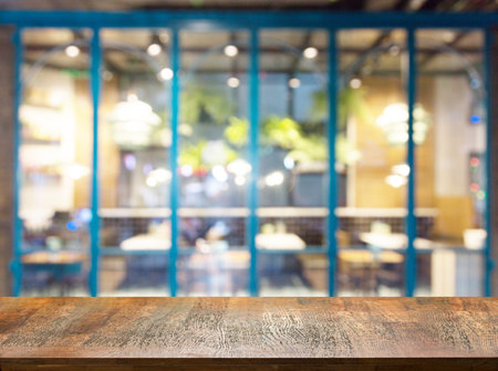 wood table top with blurred in coffee shop or cafe on backgroundの写真素材