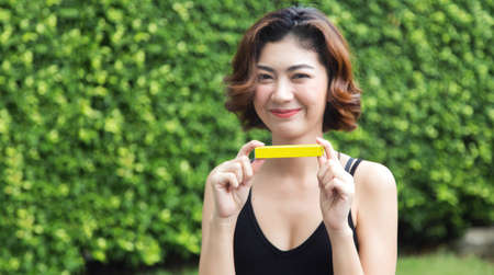 focus box and hand of asian woman show product for present on outdoor parkの写真素材