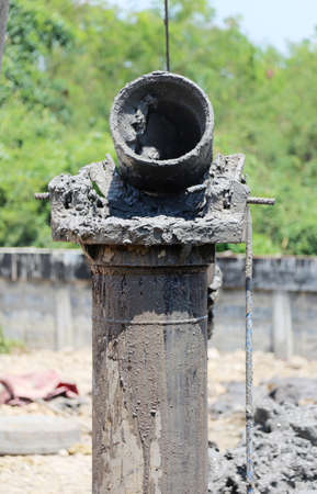 close up drilling iron pipe pull up soil underground and making cement pole of house construction