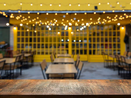 wood table top on yellow restaurant for dinner party display food and product
