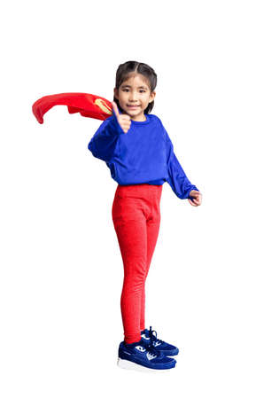 Little child plays superhero. Kid on the background of bright blue wall. Girl power concept.の写真素材