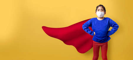 strong heroes with wearing medical mask concept. The asian girl model in action with superheros dress and wearing face mask on white isolated background (include path)の写真素材