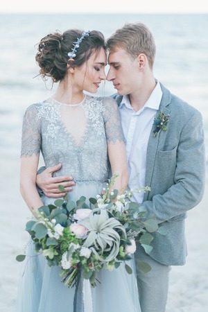 Newly-weds cuddling at the seashore.の写真素材