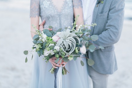 Newly married couple holding wedding bouquet.の写真素材