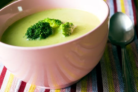 Vegetarian cream soup with broccoli on color striped clothの写真素材