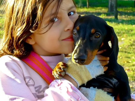 Stara Zagora, Bulgaria - October 23, 2010, Happy girl enjoys his dachshund dog and kissed him in the park.のeditorial素材