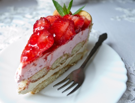 Homemade cake parfait slice with fresh sliced ââstrawberries on white plateの写真素材