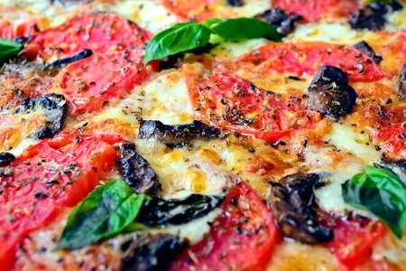 Pizza with mozzarella, tomatoes, mushrooms and basil - cleseupの写真素材