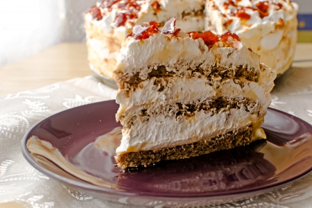 Delicious cake with cream and topped with crunchy caramel piecesの写真素材