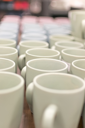 Many coffee mugs in a line over a buffetの写真素材