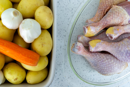 Chicken legs on a baking and fresh vegetablesの写真素材