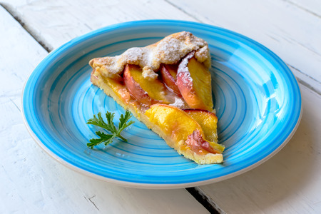 Homemade rustic peach galette on wooden tableの写真素材