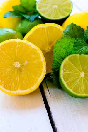 Citrus fresh fruits - lemon and lime on the white wooden tableの写真素材