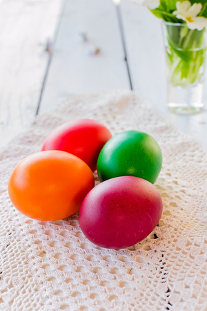 Colorful Easter eggs on white wooden tableの写真素材