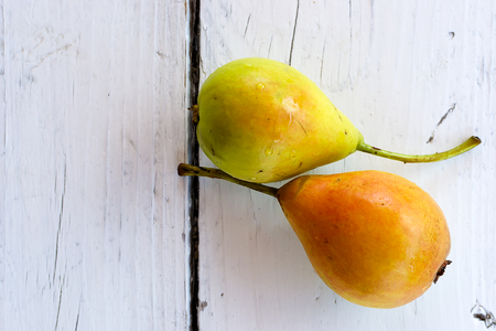 Two fresh and ripe pears  on white wooden tableの写真素材