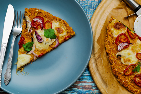 Pizza with blat of sweet potato and oat seeds, garnished with mushrooms, onions, mozzarella and cherry tomatoesの写真素材