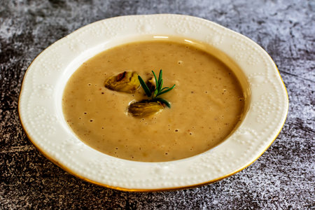 A plate of cream soup of chestnut served at the tableの写真素材
