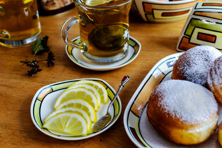 Doughnut dusted with powdered sugar for breakfast with herbal teaの写真素材