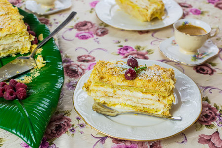 A piece of dessert Napolen garnished with raspberries for consumption on the tableの写真素材