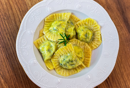 Serving Homemade Pasta Ravioli with Cow Butter Sauce in a white plate on the tableの写真素材