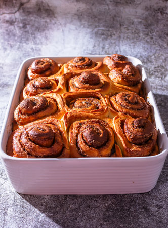 Ceramic plate with freshly baked cinnamon rolls with a nice brown tanの写真素材