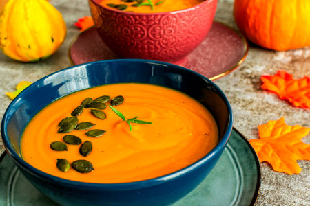 Diet pumpkin soup in a blue bowl on a gray backgroundの写真素材