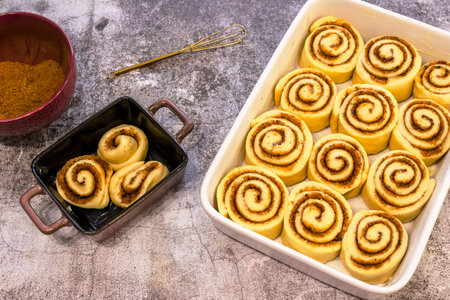 Ceramic plate with raw cinnamon rolls on a wooden tableの写真素材