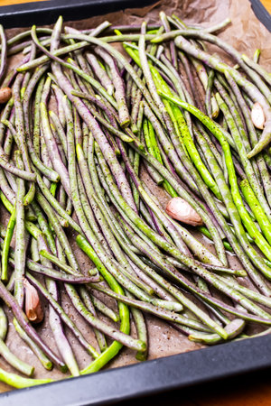 A bunch of fresh organic asparagus beans prepared with spices and salt for roasting in the oven