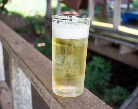 Glass of beer on the wooden rowの写真素材