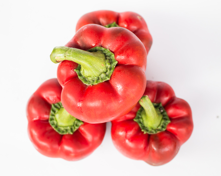 Red sweet peppers on white backgroundの写真素材