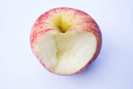 Red apple was bitten on white backgroundの写真素材