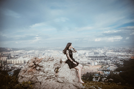 Beautiful women see the city scenery on the mountainの写真素材