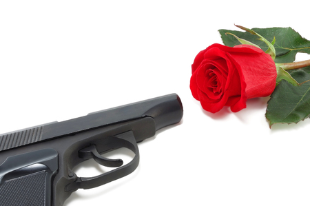 pistol and a red rose isolated on white backgroundの写真素材