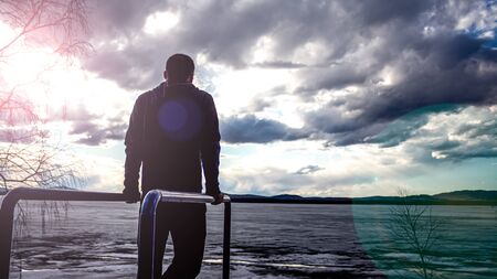 athlete in training. A man in a sweatshirt at the playground. silhouette of a man on uneven bars....