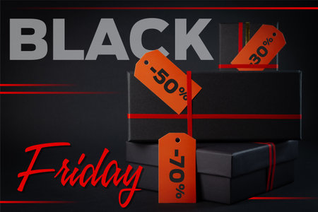 Black Friday sale concept. Black gift boxes with red ribbons on black background.の写真素材