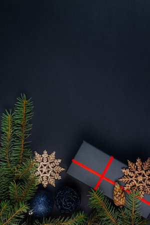 Christmas composition. Gifts, fir tree branches on black background. Christmas, winter, new year concept. Flat lay, top view, copy spaceの写真素材