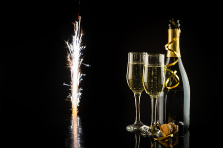 Champagne bottle and two glasses on a black background with sparklers. New Year and Christmas celebration concept.の写真素材